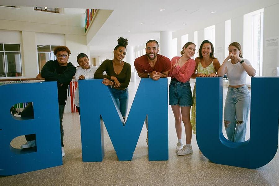 group of students in front of a large UMB letter sculpture.